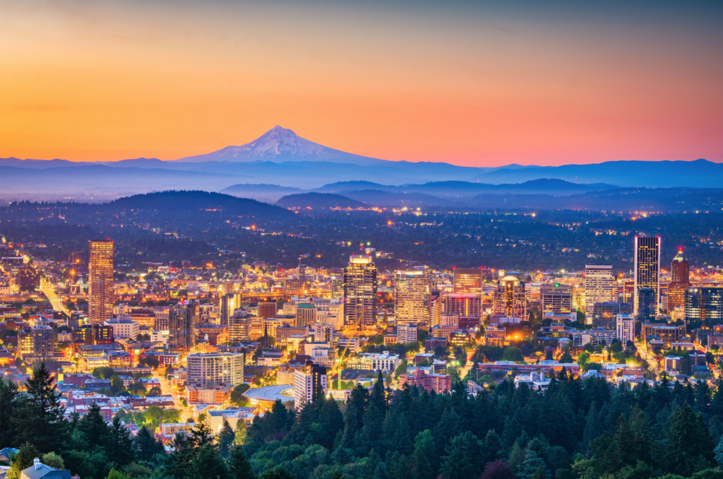 A view of downtown Portland, Oregon lit up by lights at dusk.