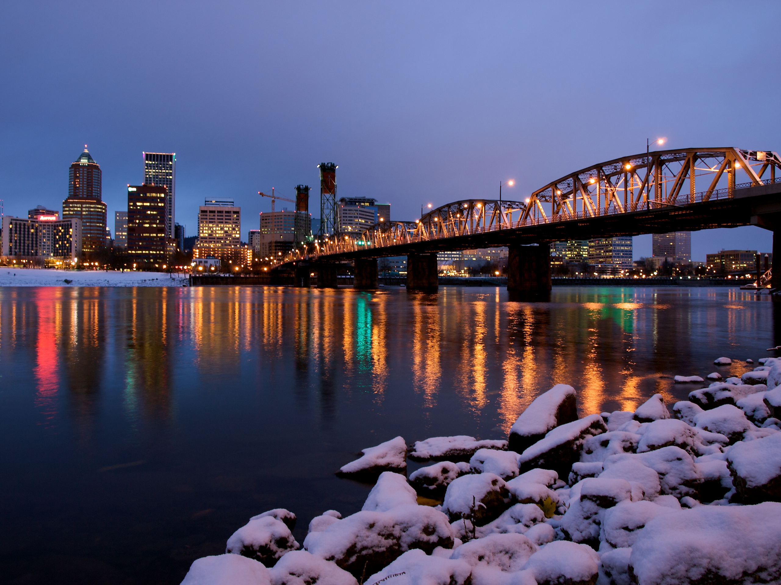 The city lights of Portland Oregon during winter with snow on the ground.